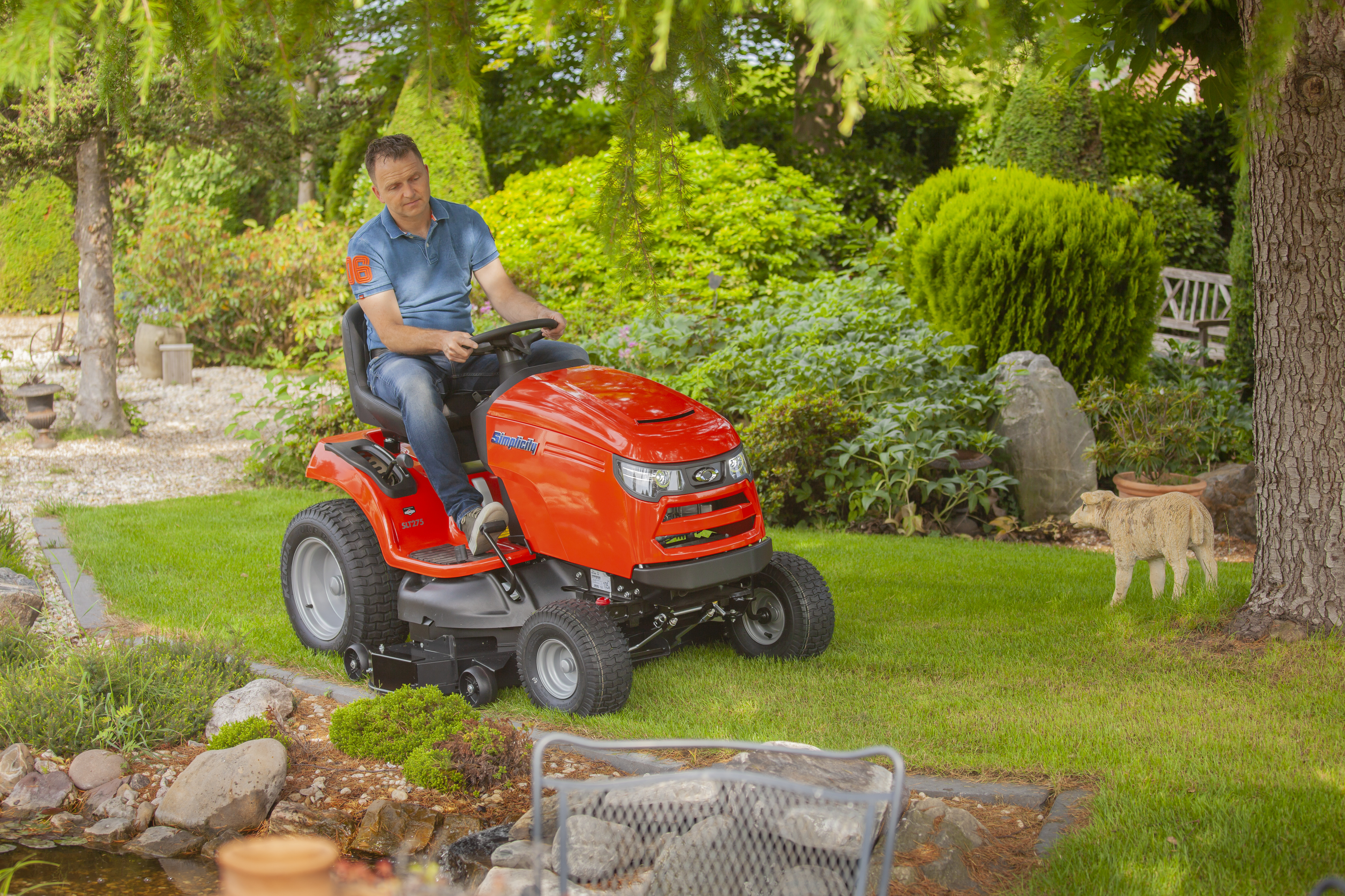 Man maait het gras met een rode Simplicity zitmaaier